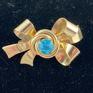 Vintage Coro gold tone bow brooch with blue rhinestone center